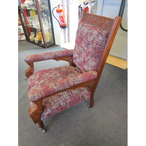 1104 - An Arts & Crafts mahogany armchair with carved decoration on turned fore legs and ceramic castors