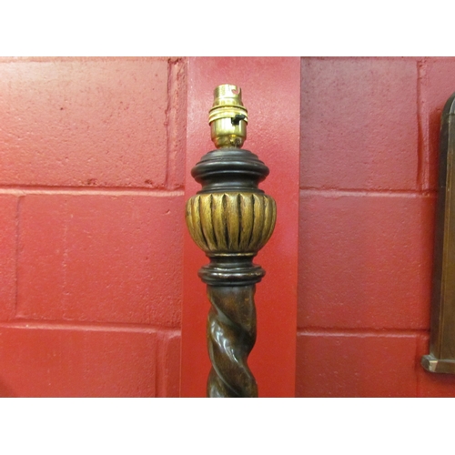 4174 - An oak barley twist and fluted standard lamp with gilt relief on a dragoon carved circular base