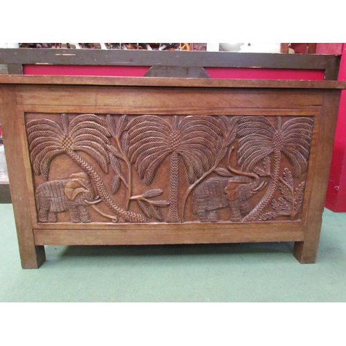 4016 - A heavily carved African blanket chest depicting figures and animals under palms, 56cm tall x 94cm w... 