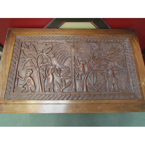 4016 - A heavily carved African blanket chest depicting figures and animals under palms, 56cm tall x 94cm w... 