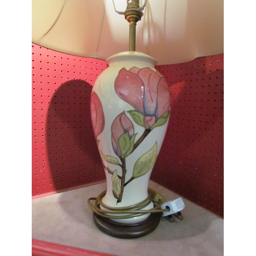 4053 - A Moorcroft magnolia pattern table lamp, cream ground with pink floral design, with shade