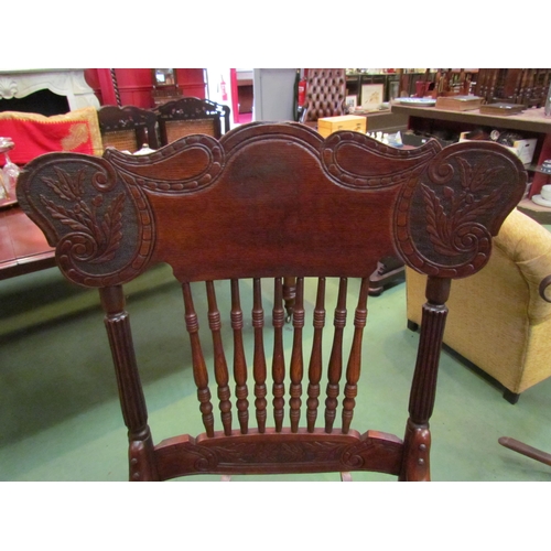 4190 - An Arts & Crafts carved oak rocking chair with ring turned spindle supports having bentwood arms ove... 