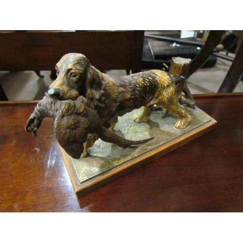 4206 - A painted spelter table lighter as a spaniel carrying a pheasant (striker missing) 16cm tall