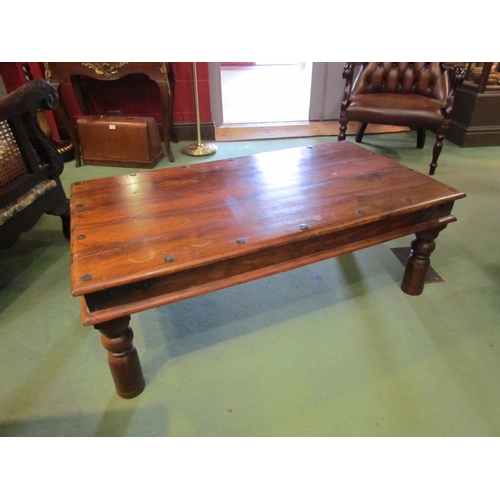 4231 - An Eastern hardwood coffee table with metal rivets, 60cm x 105cm x 40cm tall