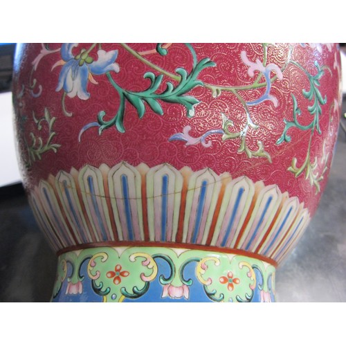 4076 - An early 20th Century Chinese polychrome lidded vase, painted with a foliate design on an ornate aub... 