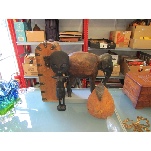 1186 - A wooden and metal figure of elephant on stand, Eastern wine bottle holder, ethnic figure and pear o... 