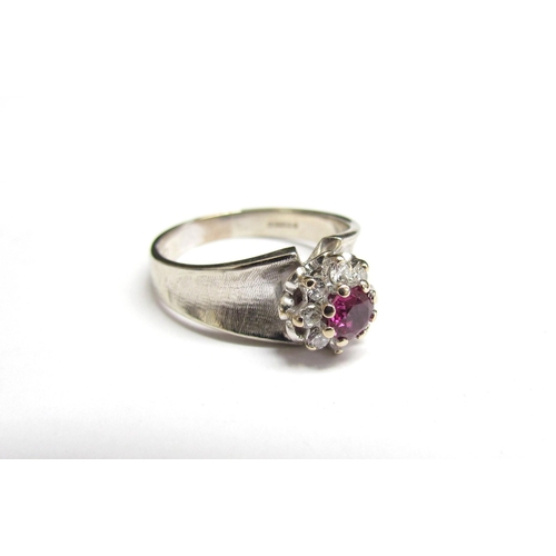 8062 - An 18ct white gold ring, London 1891, the central ruby framed by diamonds. Size R, 5.8g