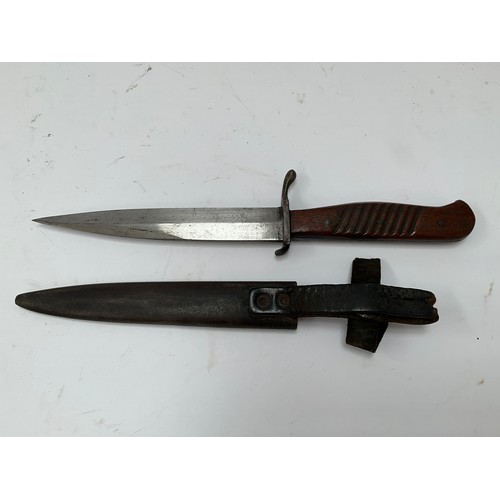 9328 - A WWI German fighting knife / trench knife, wooden ribbed grip, steel sheath with most of leather st... 