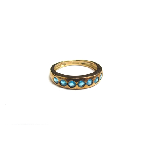 8083 - A 9ct gold ring set with seven blue apatites. Size K, 2g