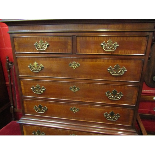 4132 - A George III style crossbanded mahogany tallboy of seven graduating long drawers over bracket feet, ... 