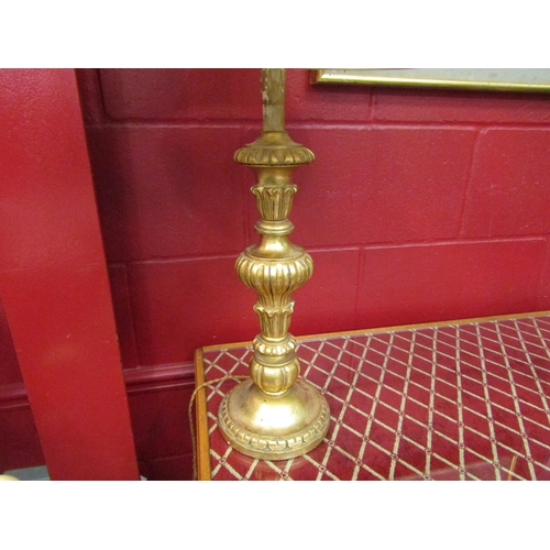 4143 - A gilt table lamp with shade, 74cm tall