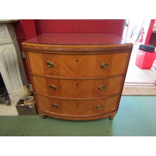 4154 - A satin walnut bow-front chest of three long drawers with decorative brass oval handles on tapering ... 