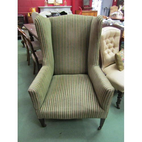 4169 - A circa 1930 wingback fireside armchair upholstered by 