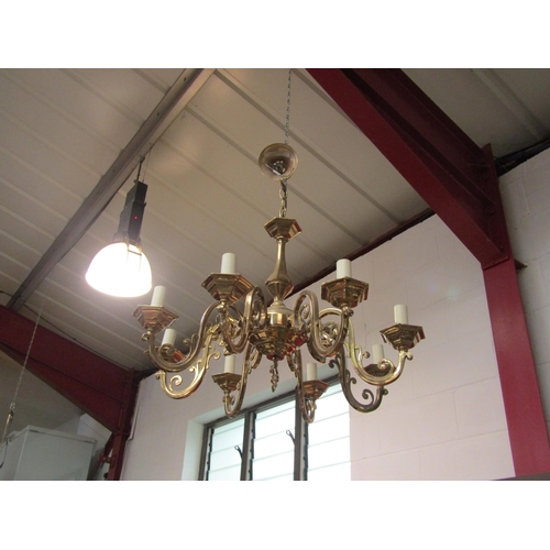 4389 - A large brass eight branch chandelier with ornate scrolled arms