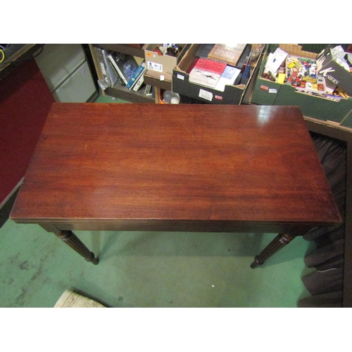 4001 - A circa 1840 mahogany table the fold-over hinged top on turned and tapering fluted legs, 76cm x 102c... 