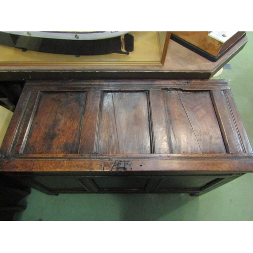 4005 - An 18th Century pegged oak three panel coffer the hinged lid over carved end stile feet, 70cm x 115c... 