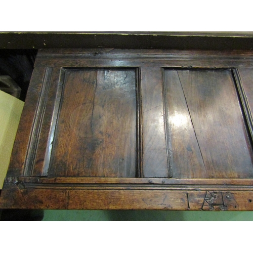 4005 - An 18th Century pegged oak three panel coffer the hinged lid over carved end stile feet, 70cm x 115c... 