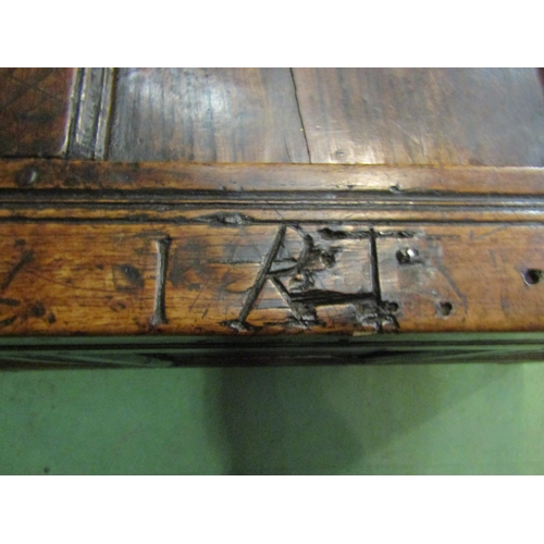 4005 - An 18th Century pegged oak three panel coffer the hinged lid over carved end stile feet, 70cm x 115c... 