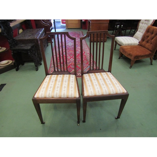 4066 - A pair of Edwardian mahogany chairs with slatted backrest over square tapering fore legs on brass ca... 