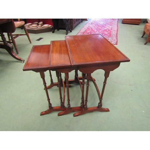 4156 - A nest of three George III style mahogany graduating occasional tables on ring-turned legs and sledg... 