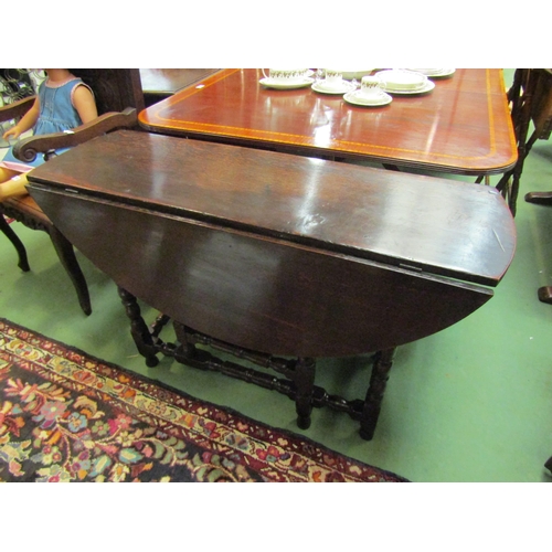 4168 - An 18th Century pegged oak gate-leg dining table the rising leaves and oval top on turned leg suppor... 