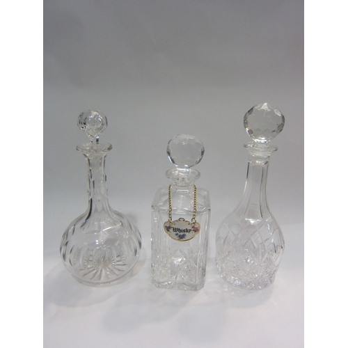 4339 - Three crystal decanters of varying forms, one with whisky label