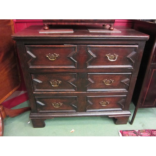 4138 - An 18th Century and later oak plank top chest of three long drawers having geometric moulded decorat... 