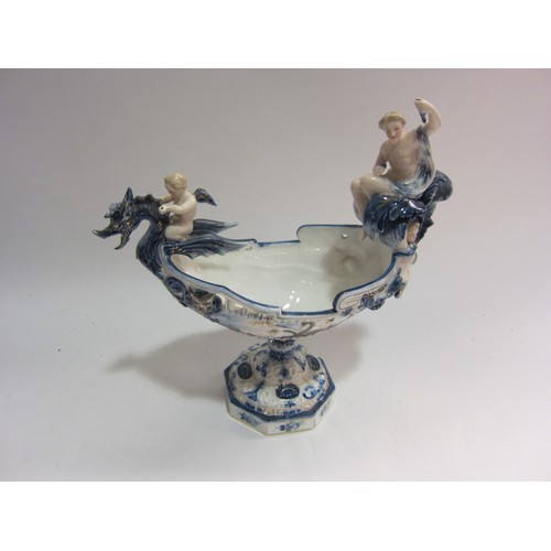 4153 - A late 19th/early 20th Century blue and white centrepiece as a boat surmounted by female and putto o... 