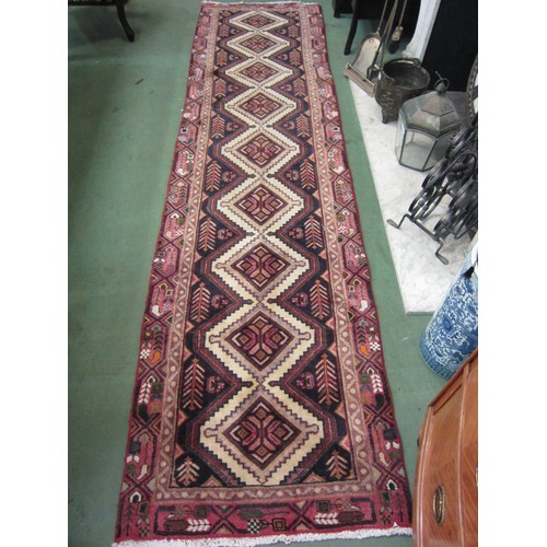 4155 - An Iranian wool and cotton red ground runner rug with diamond lozenges, 283cm x 75cm