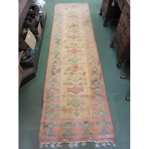 4179 - A cream and peach ground wool rug with tasselled ends, 298cm x 81cm          (E) £20-30