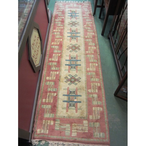 4193 - A cream and peach ground wool rug with abstract design, tasselled ends, 286cm x 85cm