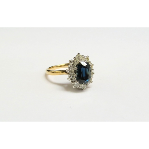 8075 - A sapphire and diamond cluster ring, the central oval sapphire framed by ten brilliant cut diamonds ... 