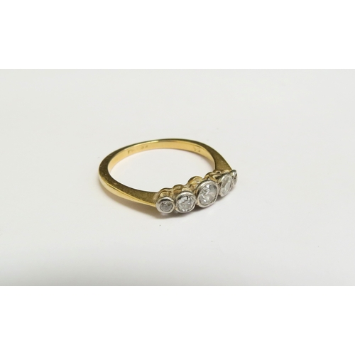 8070 - A gold ring set with five graduated diamonds in rubover setting, stamped 18ct. Size O, 2.6g