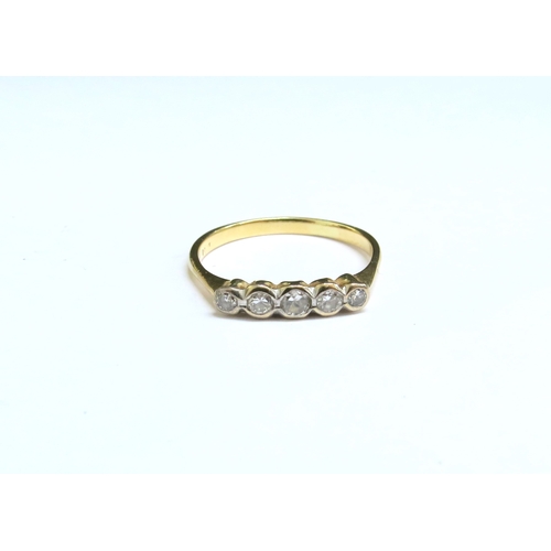 8042 - A gold ring with five graduated diamonds in rubover setting, stamped 18ct. Size R, 2.2g