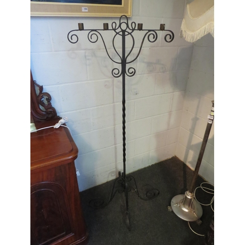 1070 - A wrought iron Gothic style floor standing candle holder with twisted stem on four scrolled feet, 15... 