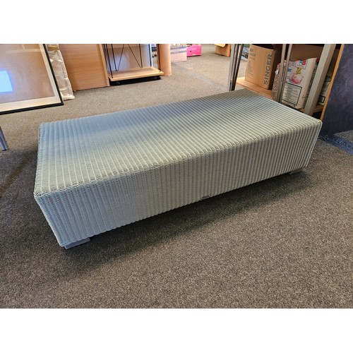 1118 - A Lloyd Loom green wicker rectangular footstool with plaque, 27cm tall x 116cm long x 57cm wide