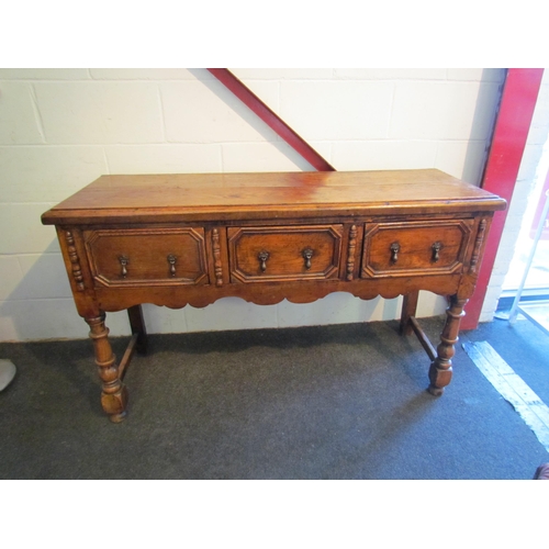 1009 - A Jacobean style oak dresser base, three drawers with geometric moulding, turned fore legs, 81cm tal... 