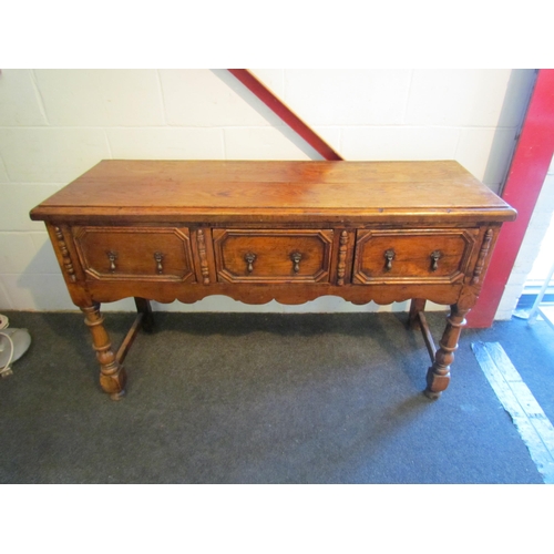 1009 - A Jacobean style oak dresser base, three drawers with geometric moulding, turned fore legs, 81cm tal... 