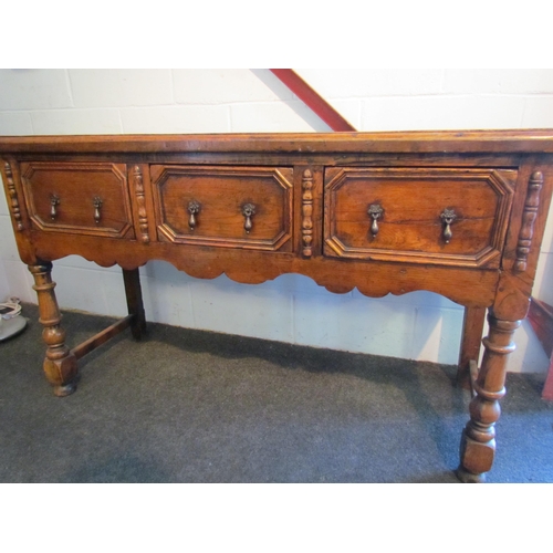 1009 - A Jacobean style oak dresser base, three drawers with geometric moulding, turned fore legs, 81cm tal... 