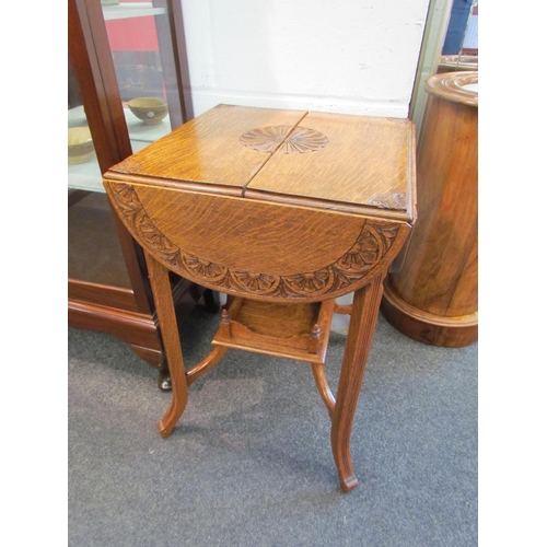 1028 - An early 20th Century carved oak occasional table, folding leaves with foliate design, with a galler... 