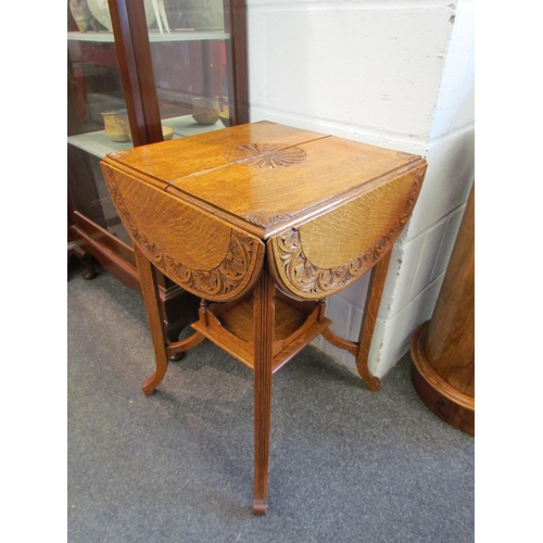 1028 - An early 20th Century carved oak occasional table, folding leaves with foliate design, with a galler... 