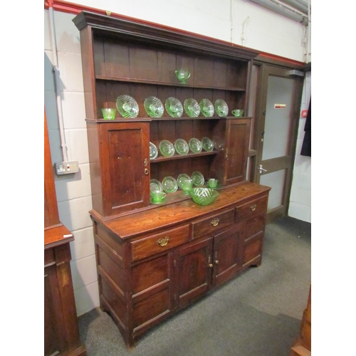 1048 - A Georgian and later oak dresser with shelved plate rack and cupboard top, over a three drawer two c... 