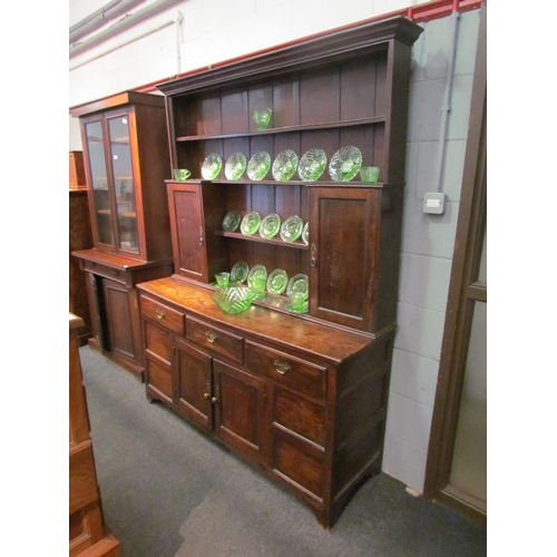 1048 - A Georgian and later oak dresser with shelved plate rack and cupboard top, over a three drawer two c... 