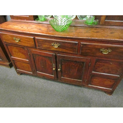 1048 - A Georgian and later oak dresser with shelved plate rack and cupboard top, over a three drawer two c... 