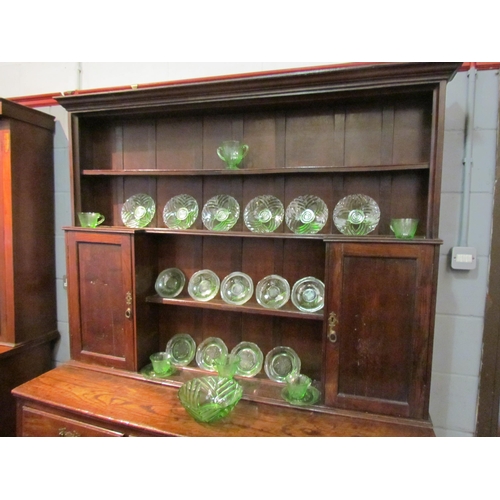 1048 - A Georgian and later oak dresser with shelved plate rack and cupboard top, over a three drawer two c... 