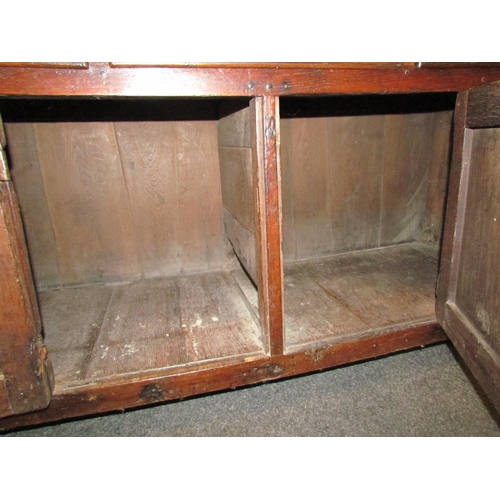 1048 - A Georgian and later oak dresser with shelved plate rack and cupboard top, over a three drawer two c... 