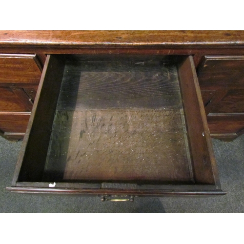 1048 - A Georgian and later oak dresser with shelved plate rack and cupboard top, over a three drawer two c... 