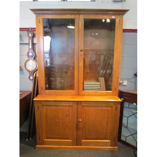 1073 - A 20th Century oak full height bookcase, the glazed top with shelved interior, over a two door cupbo... 