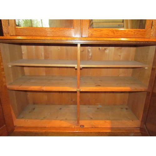 1073 - A 20th Century oak full height bookcase, the glazed top with shelved interior, over a two door cupbo... 