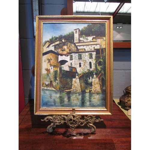 1078 - A gilt framed oil on board depicting the Swiss village of Gandria, Lake Lugano, signed Holly lower l... 